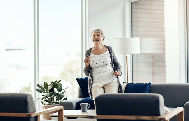 No se trata de la edad que tienes, sino de cómo te sientes. una mujer mayor bailando en casa - Foto, imagen