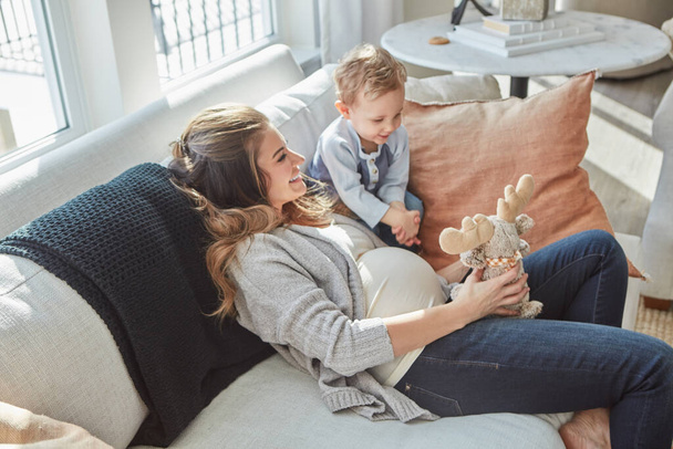 Were ready to share all the toys and our love. a pregnant woman bonding with her toddler son at home - Foto, Bild