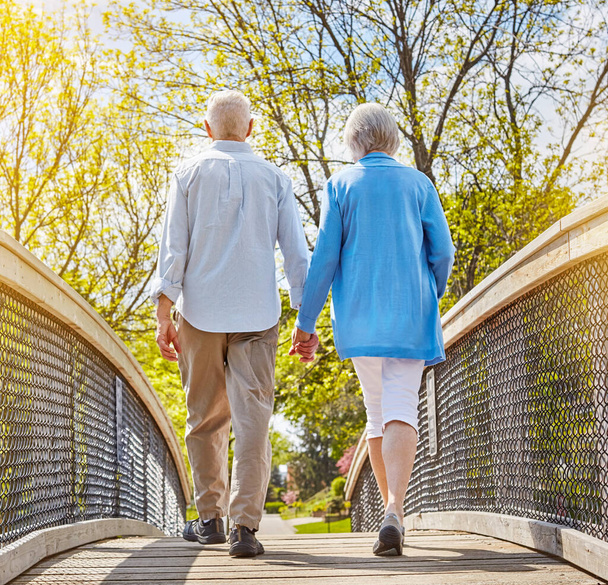 Life is all about who you have beside you. Rearview shot of a senior couple going for a relaxing walk together outside - Foto, Imagen