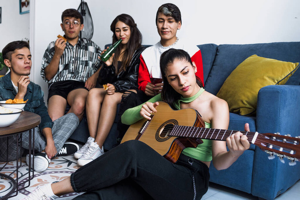 Bir grup LGBT Latin arkadaşı gitar çalıyor ve Meksika 'da evde eğleniyorlar, Latin Amerika' da Latin homoseksüel ve lgbtq toplulukları - Fotoğraf, Görsel