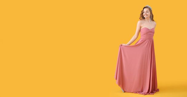 Krásná mladá žena v plesu šaty a tiára na žlutém pozadí s prostorem pro text - Fotografie, Obrázek