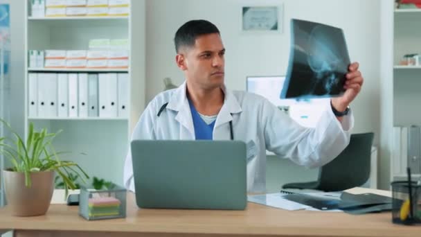 Medische röntgenfoto, man arts en laptop voor resultaten en gezondheidszorg, chirurgie of ziektekostenverzekering. Mannelijke werknemer in een ziekenhuis met een MRI-scan en technologie voor analyse, internetverbinding en telegezondheid. - Video