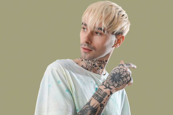 Tattooed young man on green background, closeup - Photo, Image