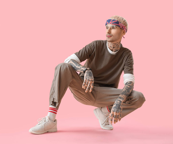 Tattooed young man on pink background - Фото, зображення