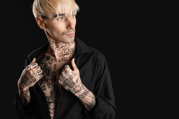 Tattooed young man on black background - Photo, Image