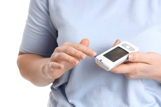 Frau mit Diabetes mit digitalem Glukometer auf weißem Hintergrund, Nahaufnahme - Foto, Bild