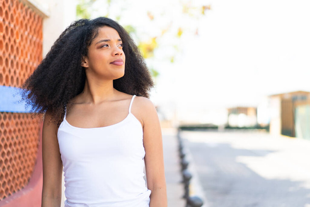 Giovane donna afroamericana all'aperto con espressione faccia confusa - Foto, immagini