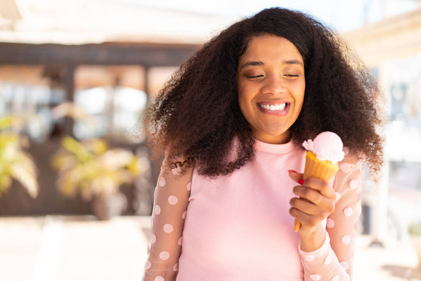 Fiatal afro-amerikai nő egy kandalló fagylalt a szabadban - Fotó, kép