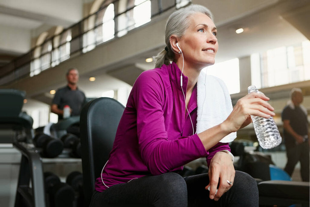 Who needs the fountain of youth if we have fitness. Portrait of a happy senior woman drinking water and taking a break from her workout at the gym - Fotoğraf, Görsel