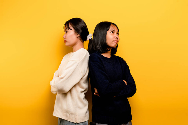 the intensity of communication misunderstanding Two friends don't talk to each other after a fight. behind the yellow background Filming of content about conflicts and misunderstandings - Foto, imagen