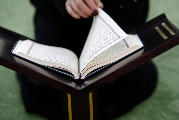 Μουσουλμάνα που διαβάζει το ευγενές Κοράνι στο τζαμί. Ντουμπάι. Ηνωμένα Αραβικά Εμιράτα - Φωτογραφία, εικόνα