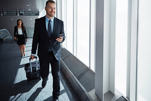 Its just like having a mobile office. two executive businesspeople walking through an airport during a business trip - 写真・画像
