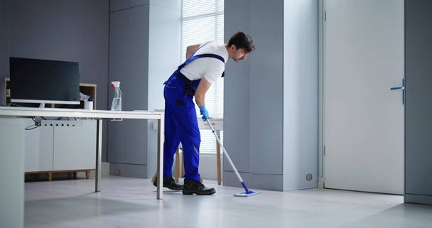 Ritratto di felice maschio Janitor pulizia pavimento a ufficio - Foto, immagini