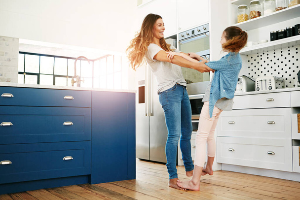 Haciendo que su infancia sea divertida. una madre y una hija felices bailando juguetonamente juntas en casa - Foto, imagen
