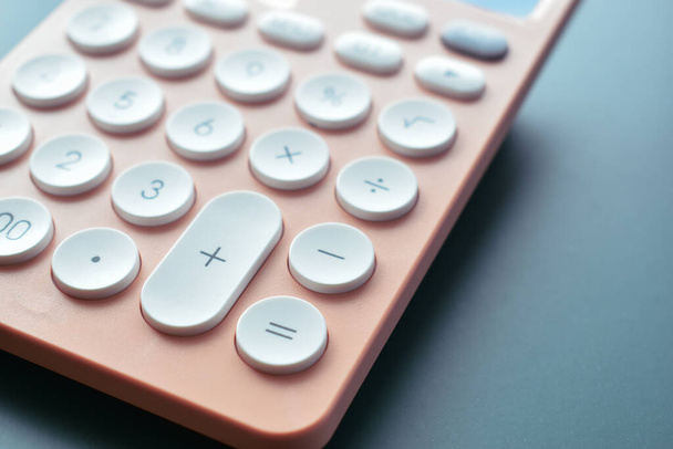zblízka moderní broskvová kalkulačka pastelových barev a bílé tlačítko na modrém pozadí, obchodní a finanční účetní koncepce - Fotografie, Obrázek