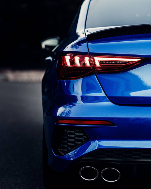A back view of a shiny blue sport car lights with blur background, vertical shot - Fotoğraf, Görsel