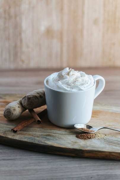 A vertical shot of a cup of hot chocolate on the wooden background - Foto, immagini