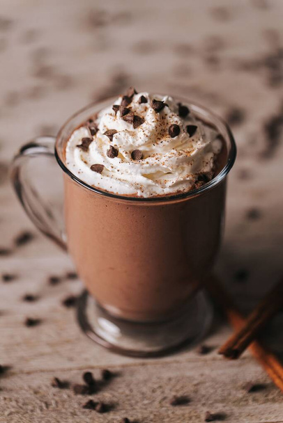 A vertical shot of a cup of hot chocolate on the wooden background - Fotoğraf, Görsel
