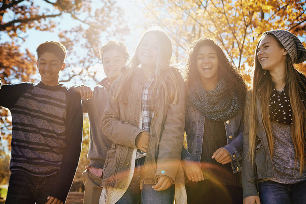 Η ζωή είναι καλύτερη όταν γελάς. μια ομάδα εφήβων φίλων που απολαμβάνουν μια φθινοπωρινή μέρα έξω μαζί - Φωτογραφία, εικόνα