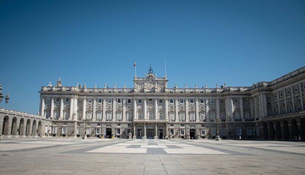 A facade shot of the Royal Palace of Madrid and its front square under the blue sky - Zdjęcie, obraz