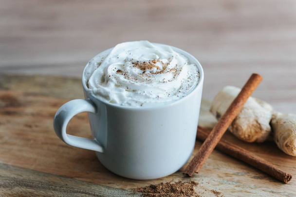 A closeup shot of a cup of hot chocolate on the wooden background - Photo, image