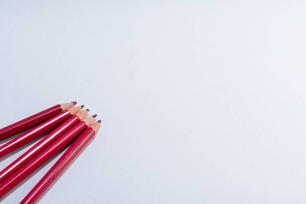 A closeup of red wooden pencils isolated on white background with copy space. - Fotó, kép