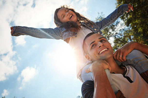 O tempo voa quando te estás a divertir. um pai feliz e filha desfrutando de um passeio de piggyback ao ar livre - Foto, Imagem