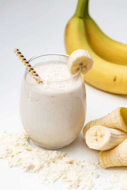A milkshake with bananas in white background - Фото, зображення