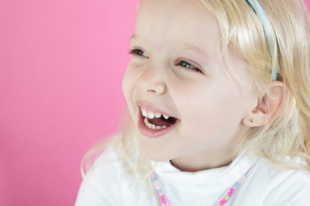 A Little blond girl isolated on pink  background - Φωτογραφία, εικόνα