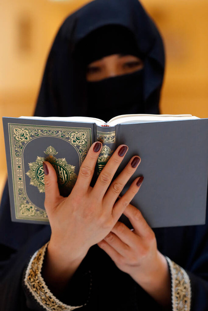 Μουσουλμάνα που διαβάζει το ευγενές Κοράνι. Ηνωμένα Αραβικά Εμιράτα - Φωτογραφία, εικόνα