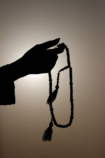 Muslimka drží v ruce modlitební korálky a modlí se proti obloze. Náboženská modlící se koncepce. Spojené arabské emiráty - Fotografie, Obrázek