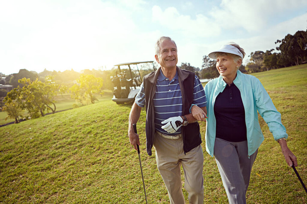 Couples golf. a smiling senior couple enjoying a day on the golf course - Foto, Imagem