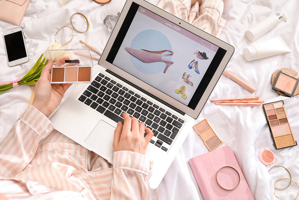 Donna con computer portatile e scultura tavolozza shopping online su coperta bianca, primo piano - Foto, immagini