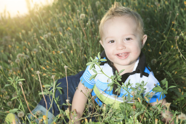 Egy kisfiú a naplementekor, egy mezőben - Fotó, kép