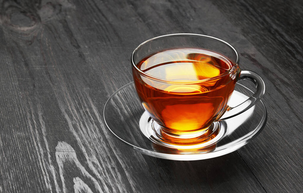 Cup of Tea op een donkere houten ondergrond - Foto, afbeelding