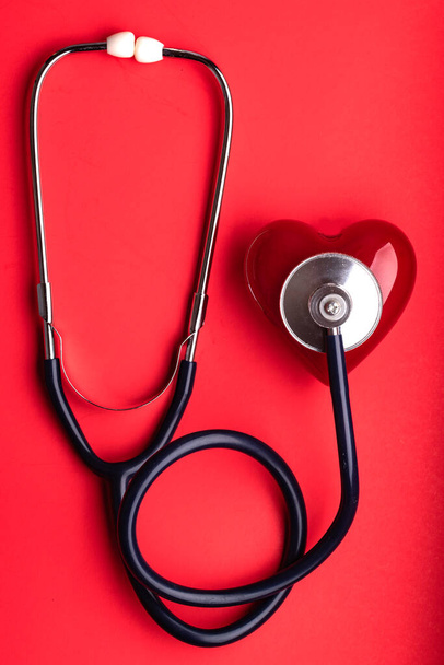 Stethoscope and red heart on red background. cardiology concept. Space for text. - Fotografie, Obrázek