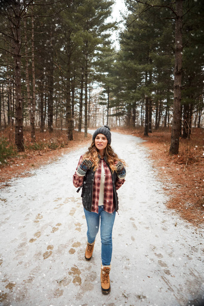 Dit is een pad dat ik moet verkennen. een jonge vrouw wandelen in de wildernis tijdens de winter - Foto, afbeelding