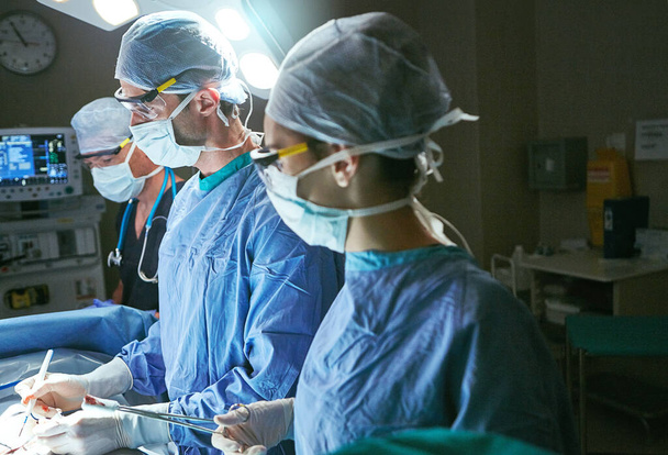 Heilung ist ihre Berufung. Chirurgen im Operationssaal - Foto, Bild