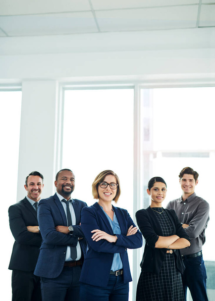 We remain strong by binding together as a single force. Portrait of a diverse group of businesspeople standing together in an office - Photo, Image