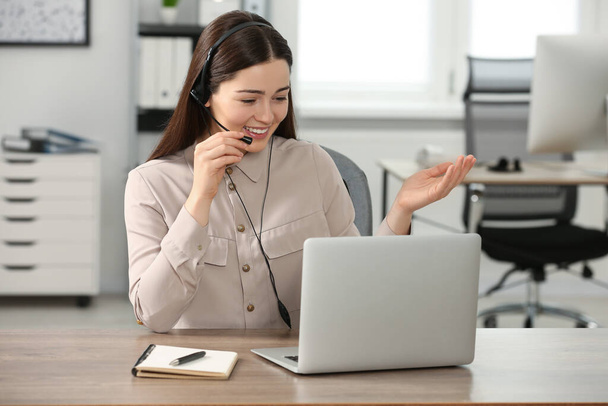 Hotline operator with headset working on laptop in office - Fotografie, Obrázek