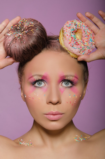beautiful woman with two donuts on head - Фото, изображение