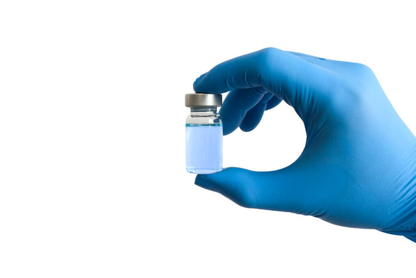 la mano del médico sostiene el frasco de vacuna azul sobre un fondo blanco aislado. Conceptos médicos y de salud. - Foto, Imagen