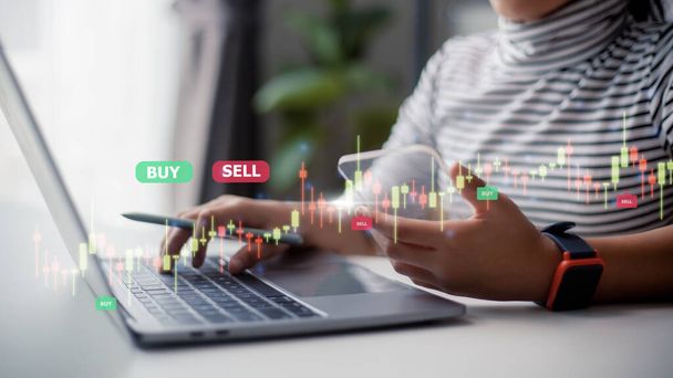 Women use laptops to analyze trading data on the futuristic virtual interface screens. smartphone with a stock exchange graph on the screen. Financial stock market. - 写真・画像