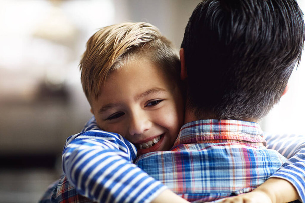 Ты просто лучший папа в мире. очаровательный маленький мальчик обнимает своего отца дома - Фото, изображение