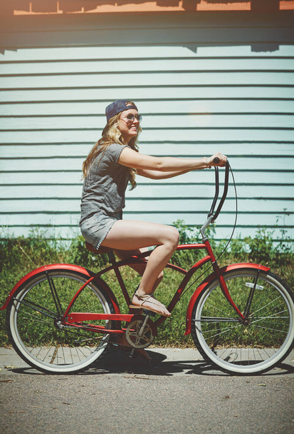 Go out and get some fun. an attractive young woman riding a bicycle outdoors - Foto, Imagen