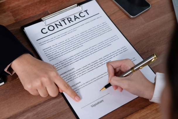 Closeup hand signing contract document with pen, sealing business deal with signature. Businesspeople finalizing business agreement by writing down signature on contract paper. Enthusiastic - 写真・画像