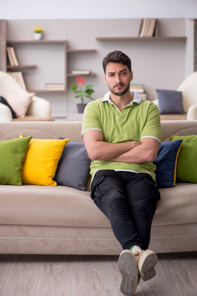 Young man with a lot of pillows at home - Foto, imagen