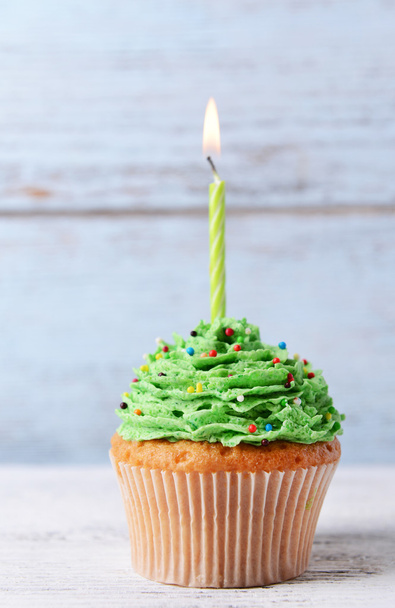 Delicious birthday cupcake on table on wooden background - Foto, Imagen