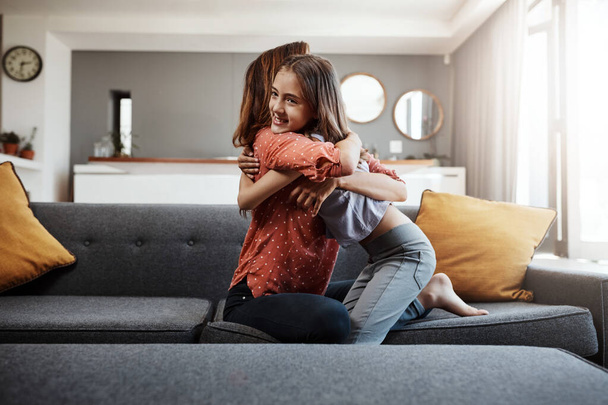 Theyre two of a kind. Full length shot of an attractive young woman and her daughter hugging while spending time together at home - 写真・画像