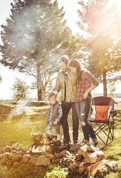 The fire is looking good. a young family camping in the forest - Photo, Image